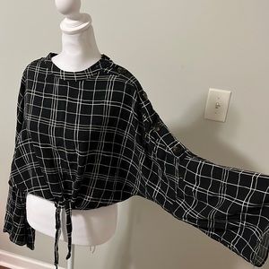 Black and white crop top with long sleeves and buttons on one sleeve